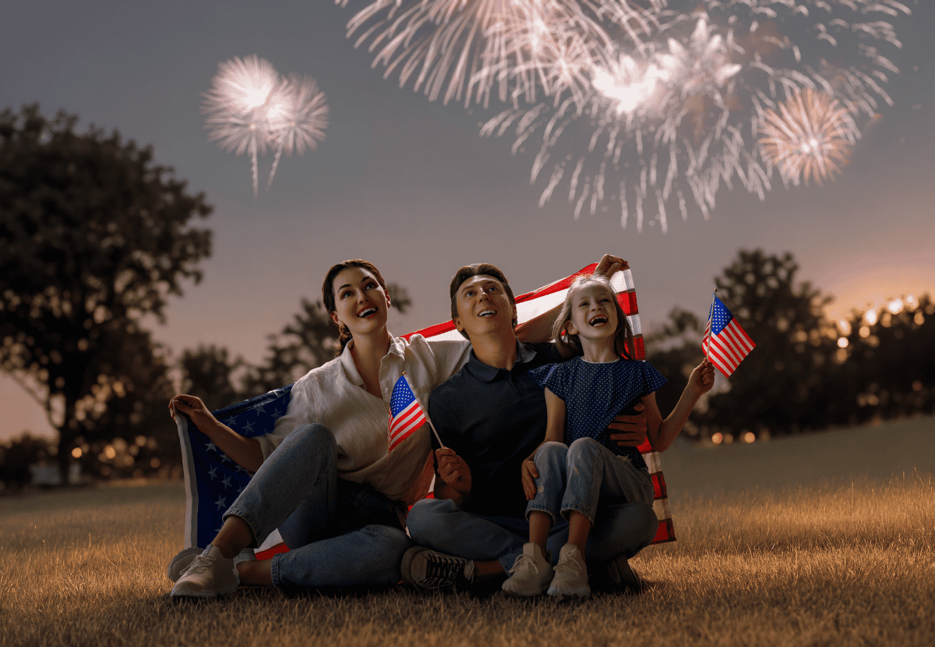 Family Celebrates with Flags at a Fireworks Display