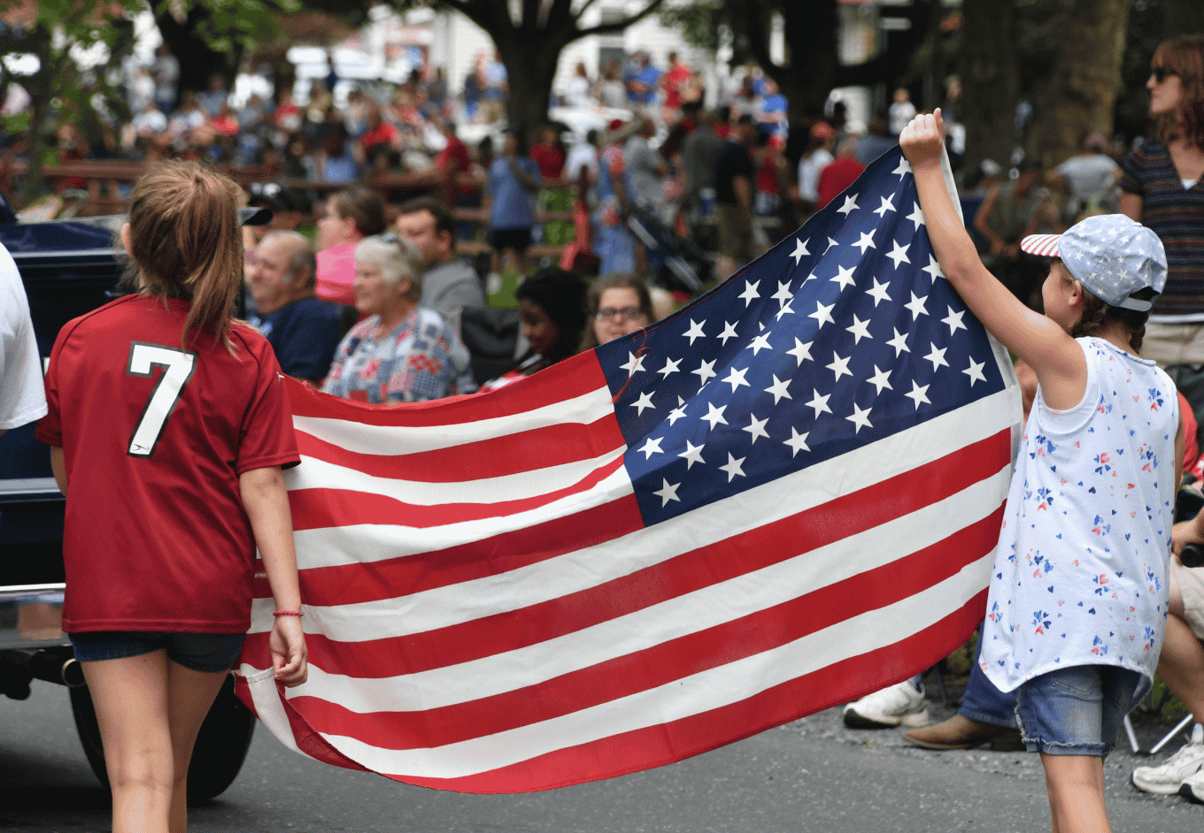 Children Celebrate with American Flag at Parade