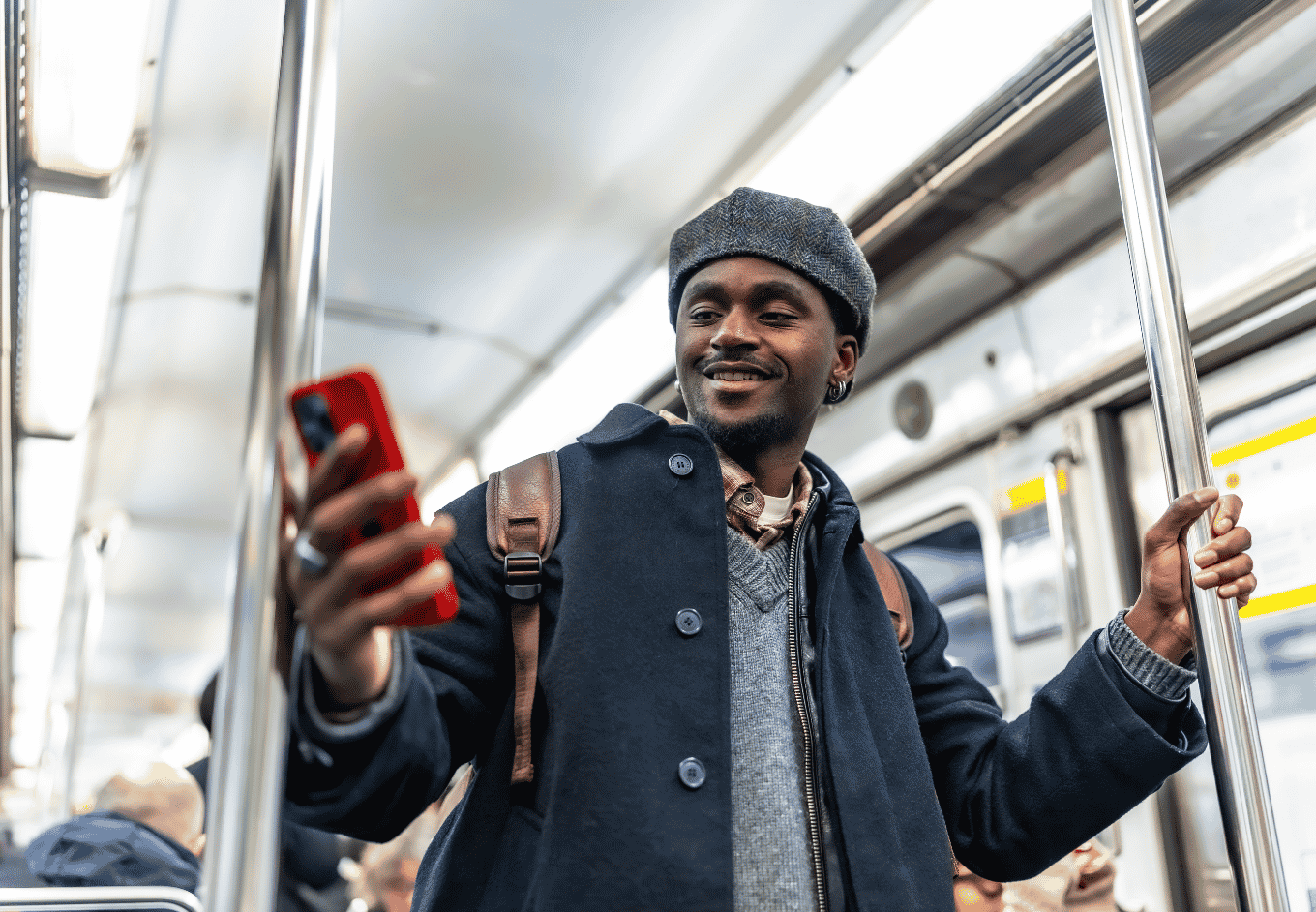 Young man commuting, enjoying using smartphone in subway