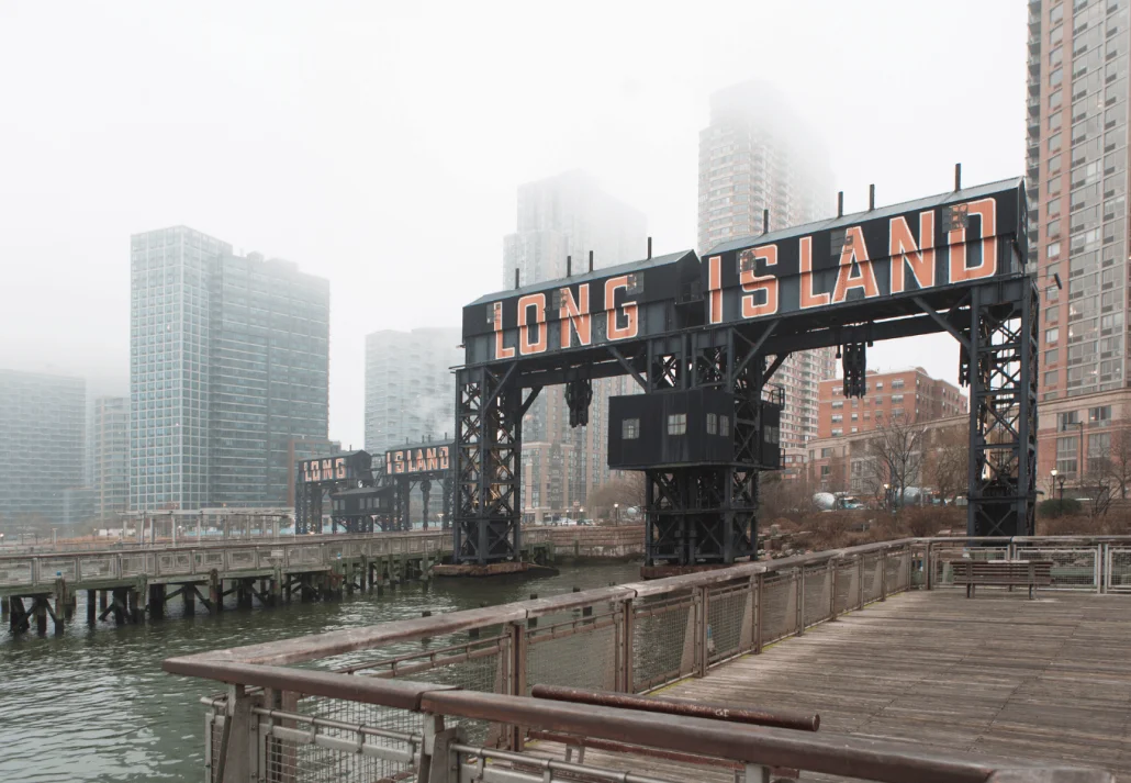 Misty view of Long Island sign with cityscape.