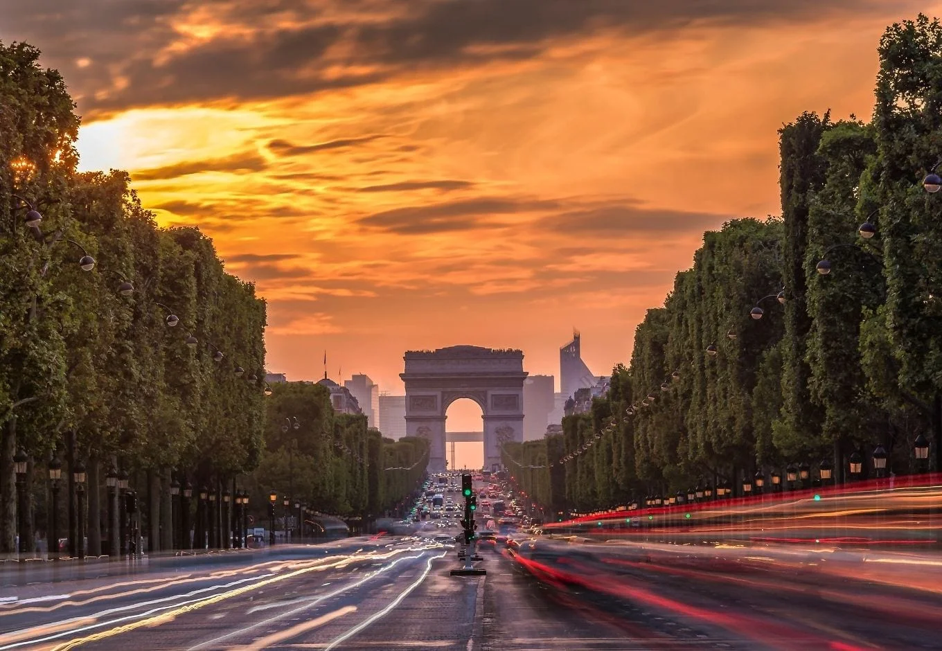 The Arc Du Triomphe at the end of the Champs Élysees Avenue at sunset in Paris.