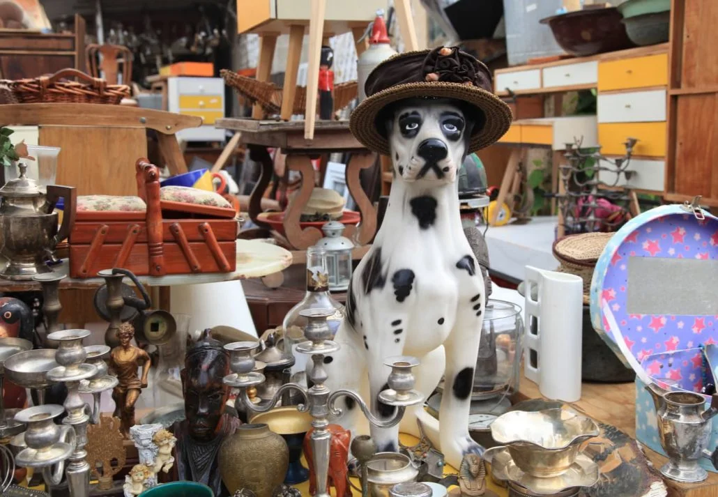 A bunch of different antique items on a stand in Ostbanhof market