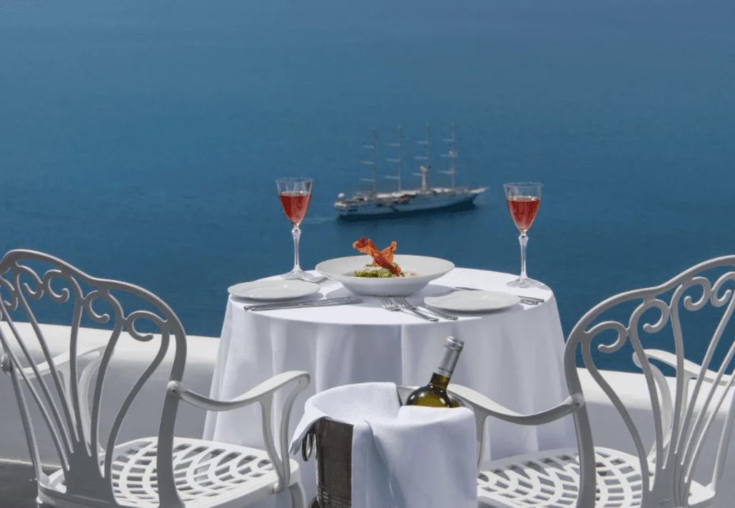 Red wine glasses on a white table overlooking the sea in Santorini