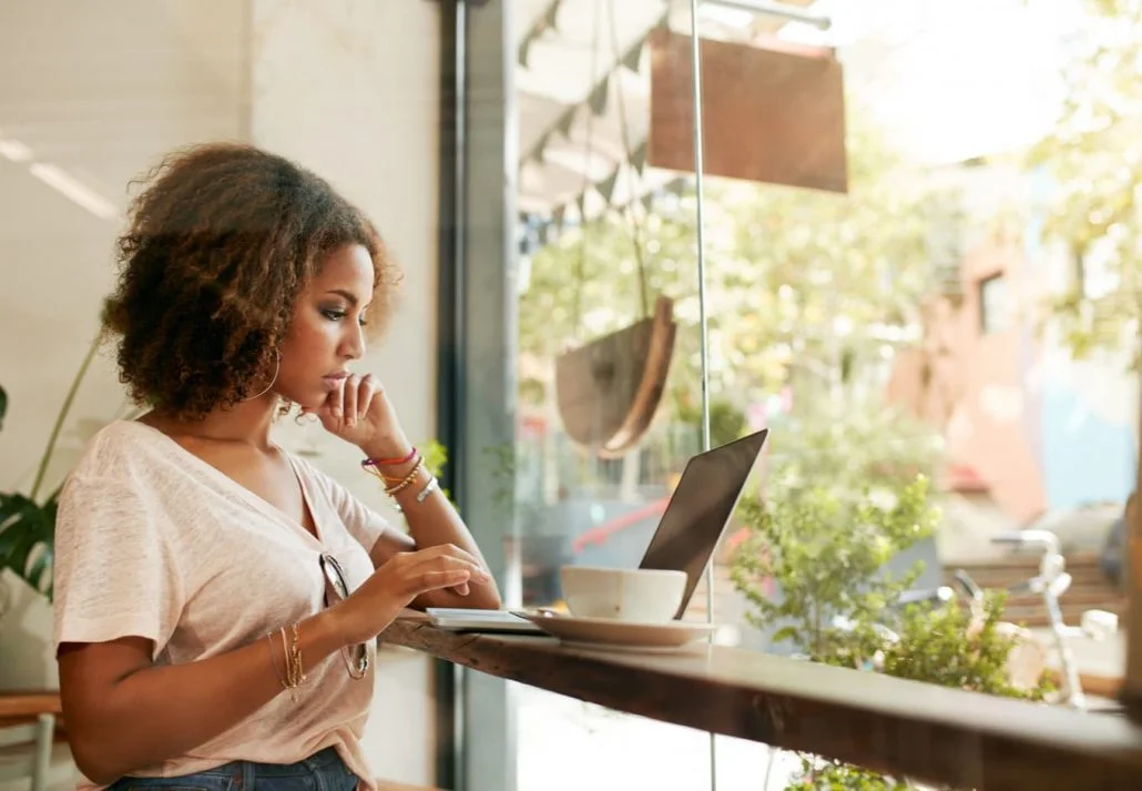 Young woman working on her laptop in a cafe.