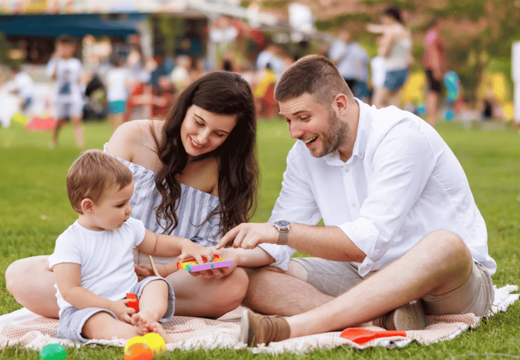 Young parents having fun on picnic with their child
