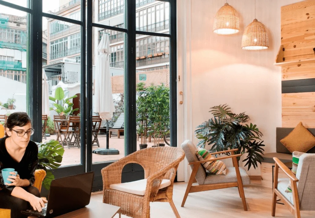 Woman in the stylish common area of Rodamon Barcelona Hostel, in Barcelona, Spain.