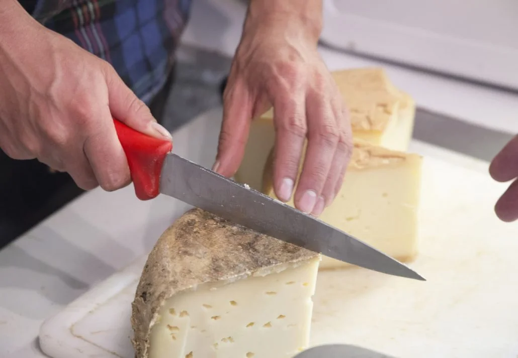 Valle de Roncal landscape in Navarre Spain Cutting farm cheese.