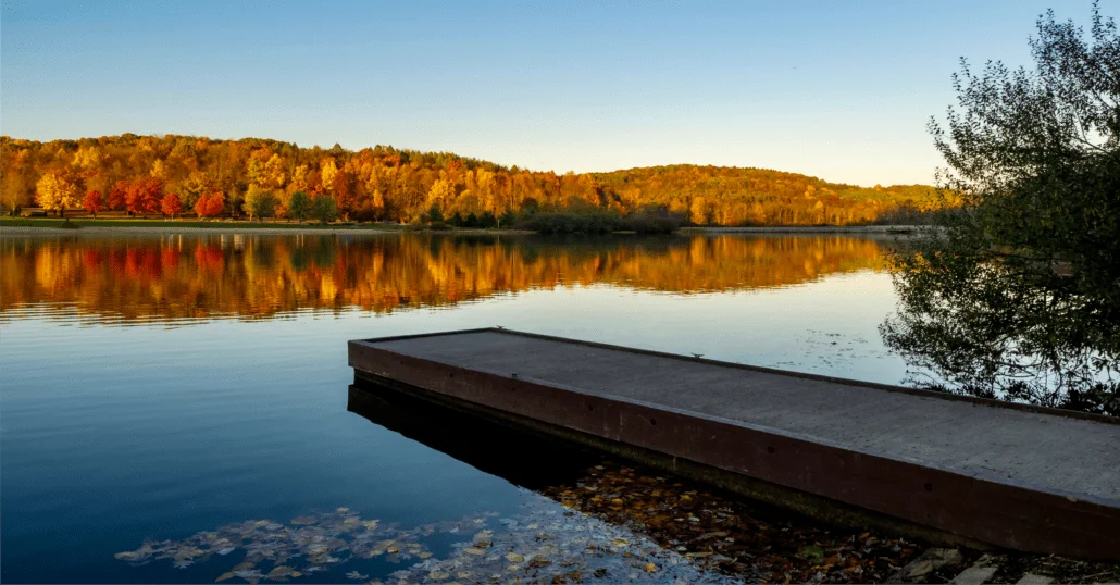 Bucolic view of a river in the US framed by trees during the peak of the fall foliage.
