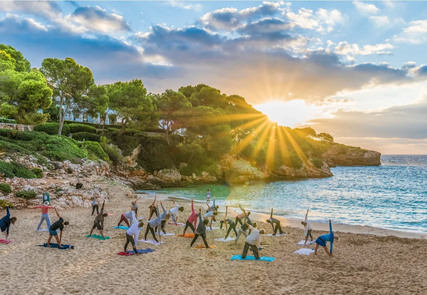 People practicing yoga at sunset time in Palma Mallorca Island, Spain