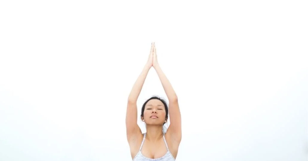 Woman doing yoga with her eyes closed.