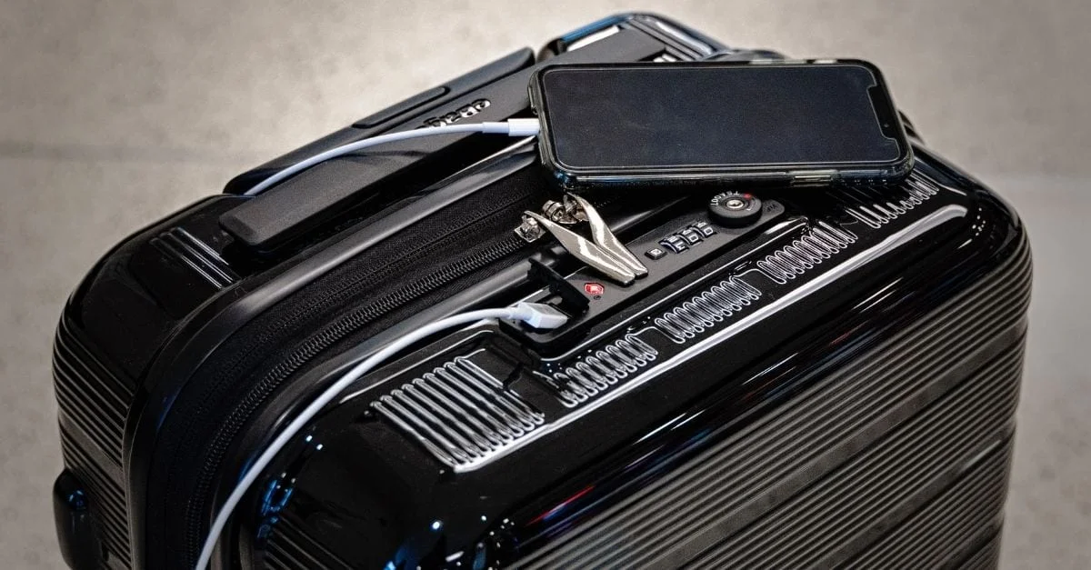 A smartphone being charged on a travel suitcase.