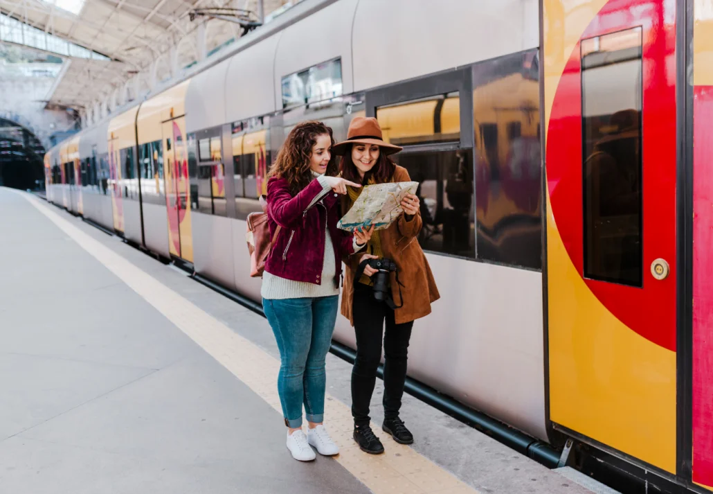 two-women-friends-at-train-station-reading-a-map