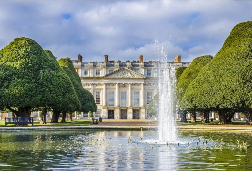 London Attractions - A water fountain and ornate trees in front ot the marvelous Hampton Court Palace, in London.