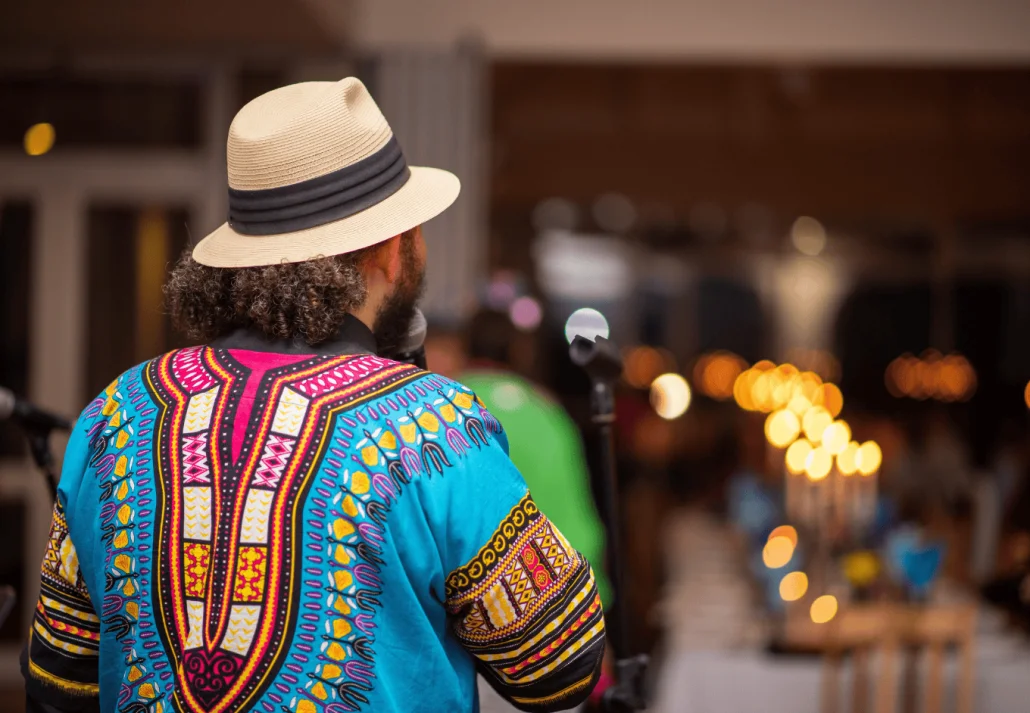 Musician with african print shirt performing shot from behind