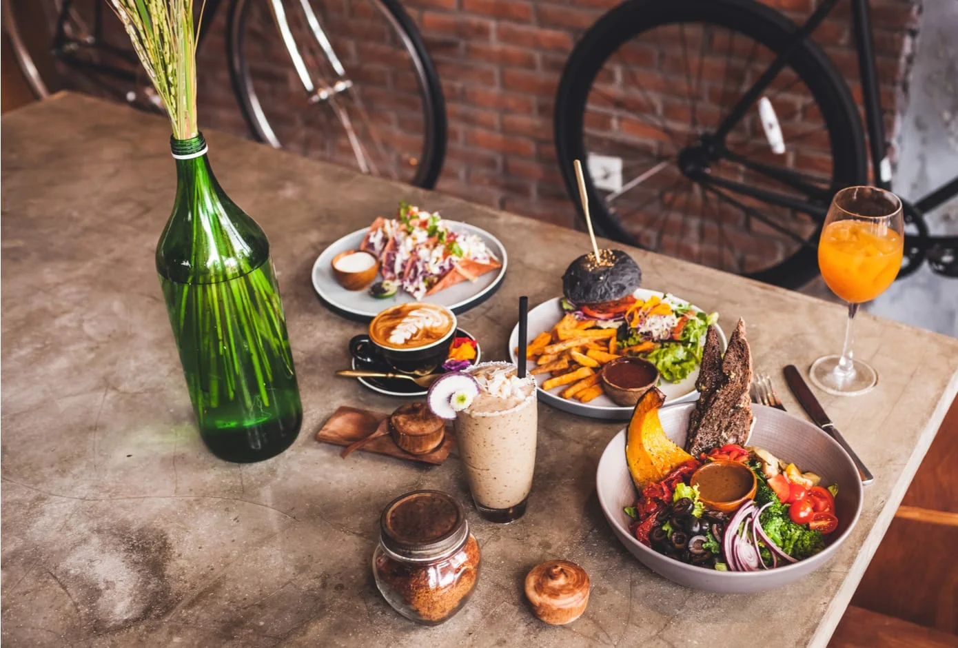 Fresh organic vegetarian food and glass of kombucha in hipster style cafe 