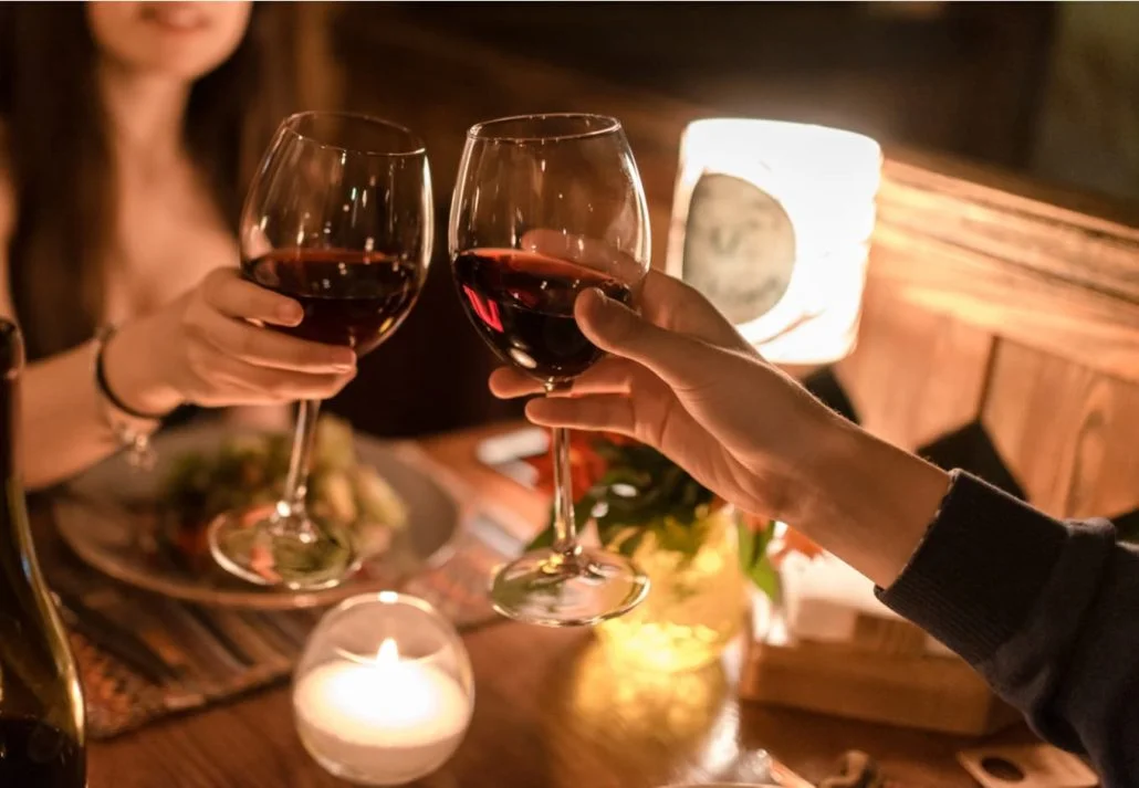 Young couple toasting with red wine during a romantic diner.